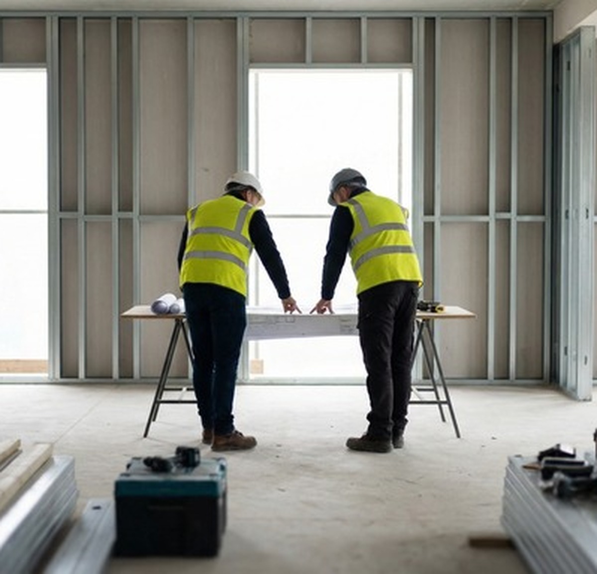 SLB Contracts site coordination with drawings and steel framing in the background
